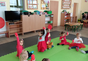 Dzieci siedzą z czerwonymi klockami